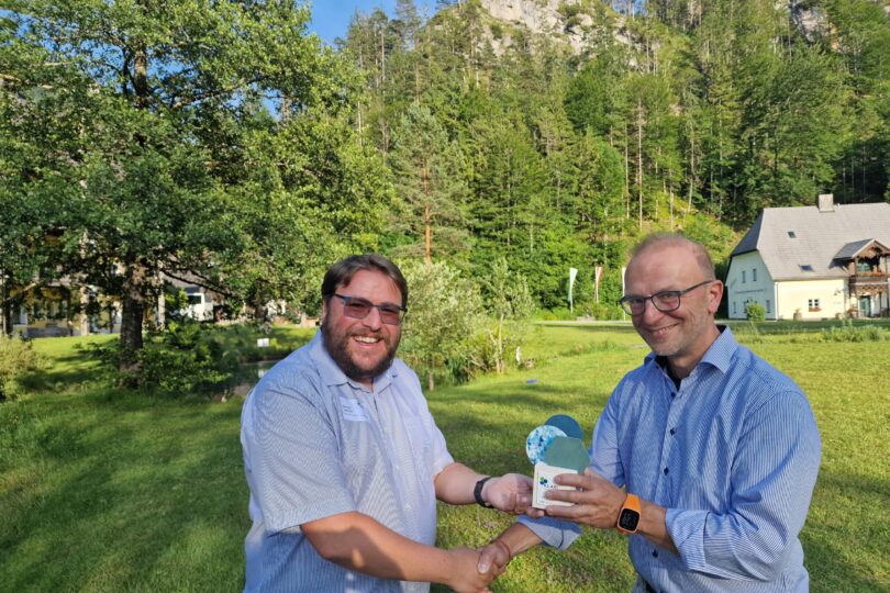 Der Geschäftsführer des Klima- und Energiefonds, Bernd Vogl, überreicht einen Pokal an den Gewinner.