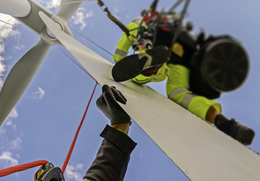 Windradtechniker:innen bei ihrer Arbeit am Windrad.