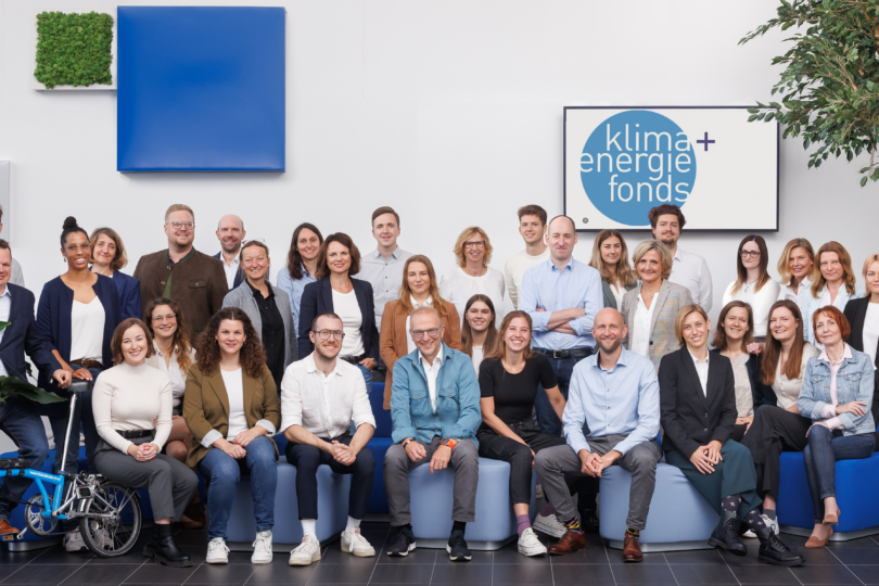 Gruppenfoto mit ca. 40 Menschen vor weißer Wand mit Bild des Klima- und Energiefonds-Logos rechts oben.