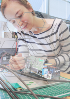 Frau im Labor, die am Schreibtisch an einer Platine arbeitet.