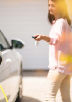 Frau vor einem Elektroauto.