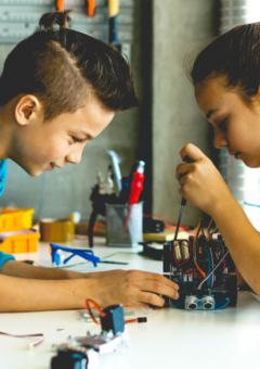 Auf dem Bild sind zwei Kinder zu sehen, die an einem wissenschaftlichen Projekt arbeiten.