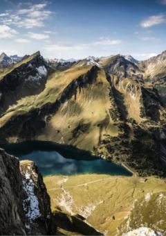 Auf dem Bild ist ein alpines Gelände zu sehen. Auf dem Gelände ist ein See.