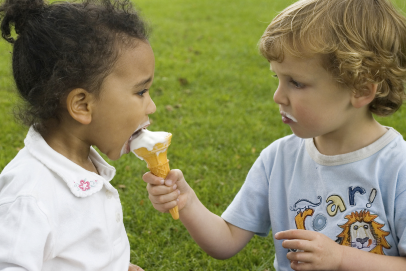 2 Kinder, die Eiscreme miteinander teilen.