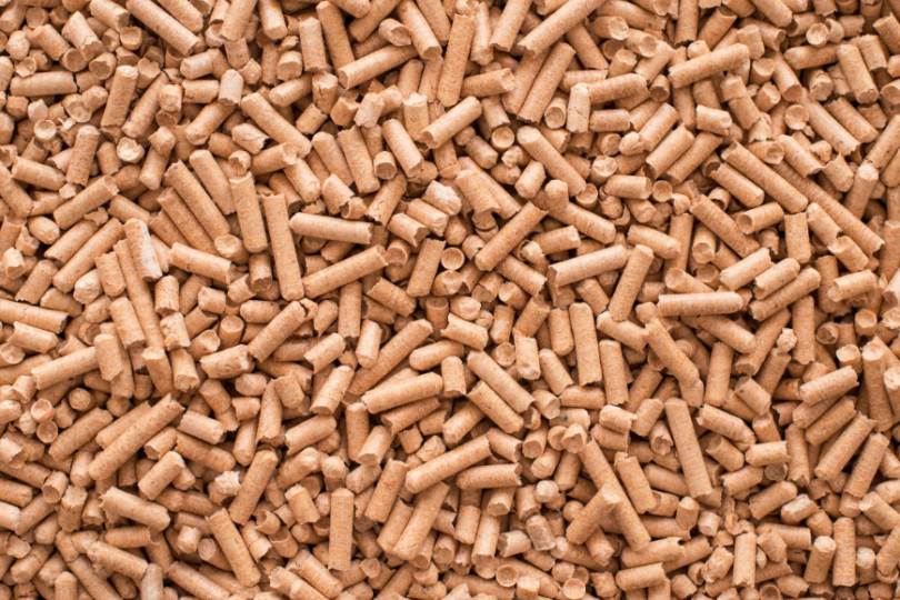 Eine Nahaufnahme von Holzpellets, die dicht aneinandergereiht sind. Die kleinen zylinderförmigen Stücke dienen als nachhaltiger Brennstoff für Heizsysteme.