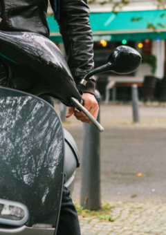 Das Bild zeigt eine Person, die auf einem Elektroroller auf einer Straße fährt.