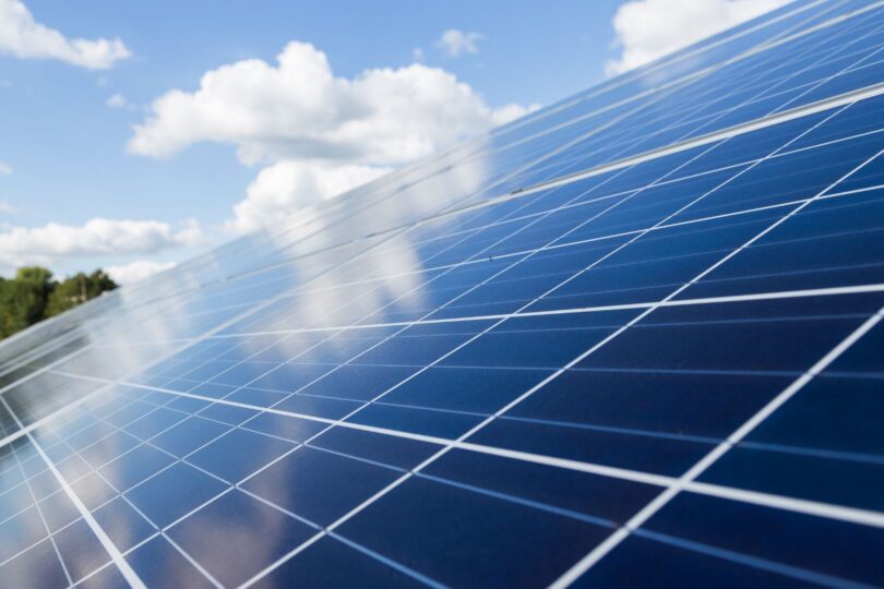 Auf dem Bild sieht man ein PV-Panel aus der Nähe und im Hintergrund blauen Himmel und Wolken.