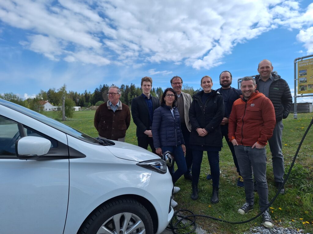 Ladende E-Auto und 8 Menschen dahinter