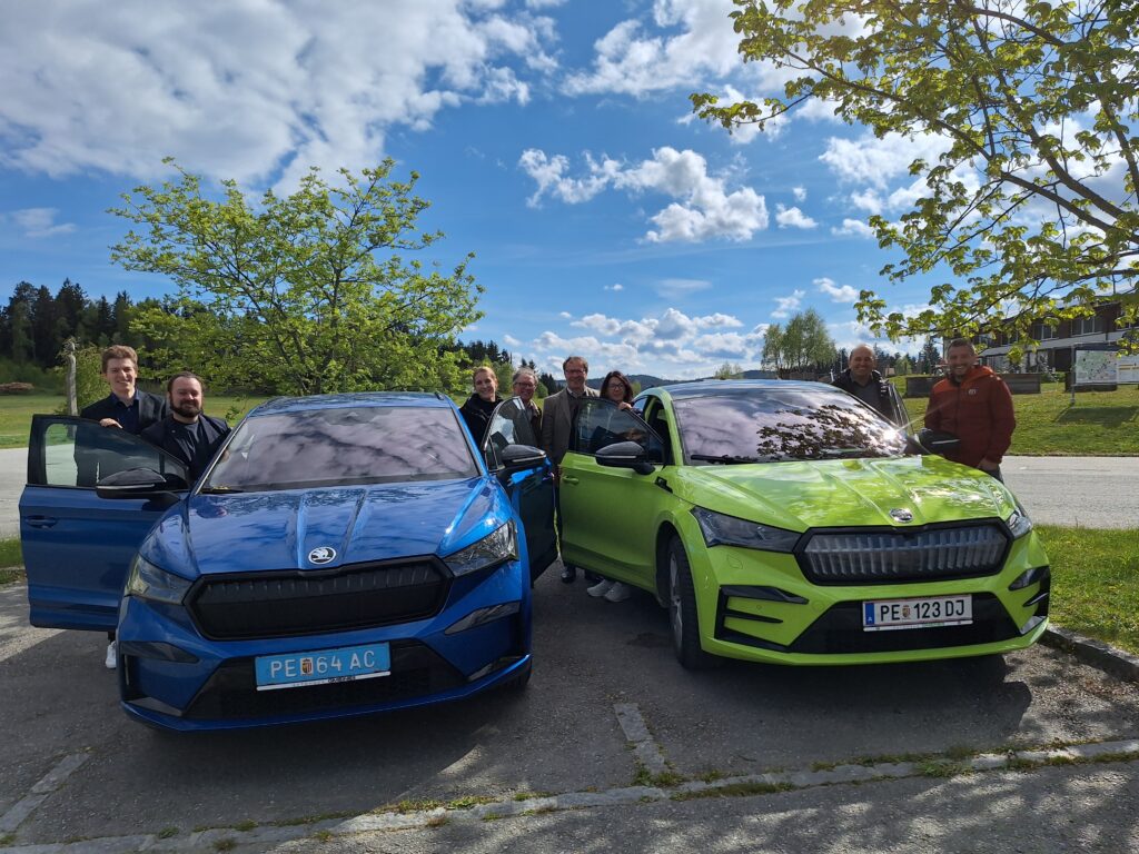 Foto aus dem Projetk Storebility2Market, zwei E-Autos und 8 Menschen an Autotüren